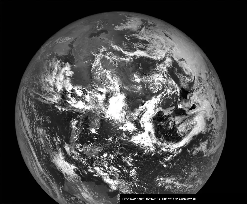 A black and white photo of the whole Earth with swirling clouds, taken by a NASA orbiter at the Moon